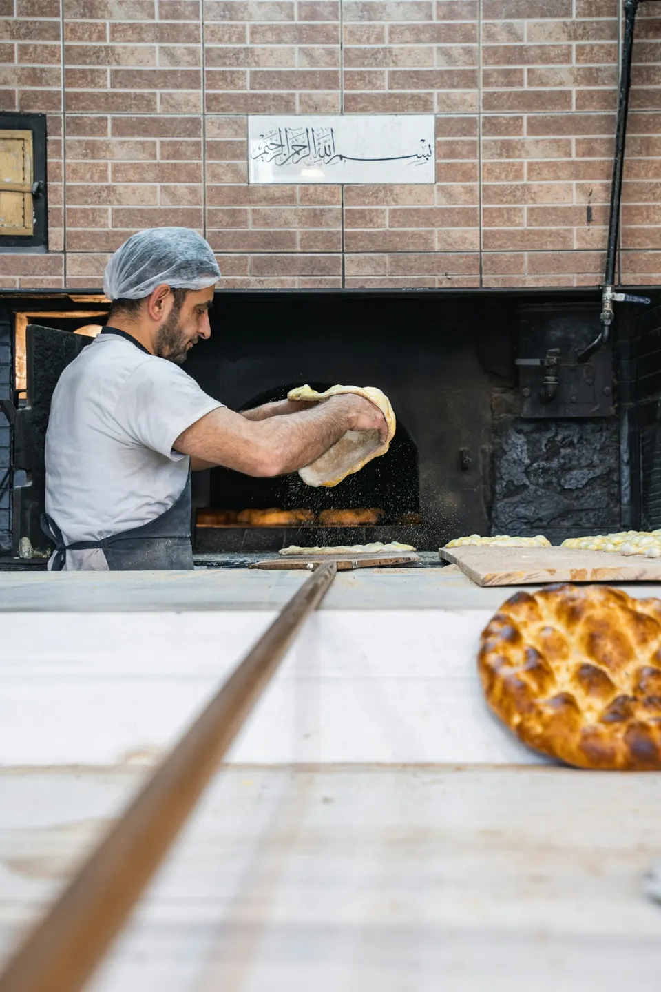 Padeiro colocando pães no forno
